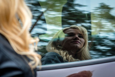 Woman reflecting on car window