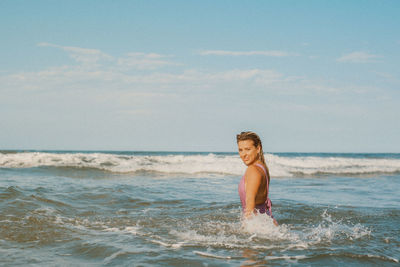 Portrait of young woman standing at beach