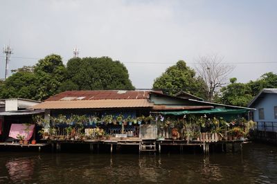 Houses by river against sky