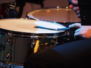 Midsection of drummer playing drums