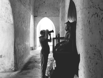 Man photographing buddha statue