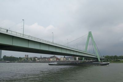 Bridge over river against cloudy sky