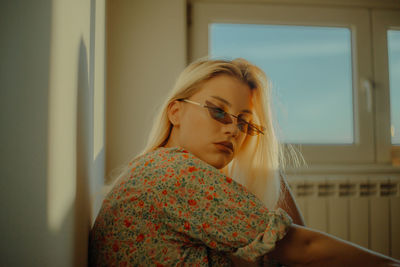 Portrait of a young woman wearing sunglasses during sunset
