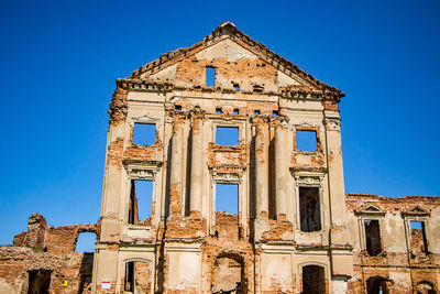 Low angle view of old building against blue sky