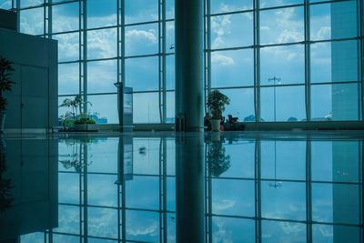 Reflection of people on swimming pool by window