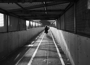 Rear view of man walking in tunnel