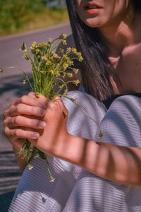 Midsection of woman holding flowering plant