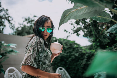 Full length of woman wearing sunglasses against plants