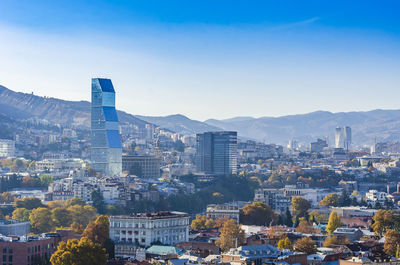 Aerial view of buildings in city against sky