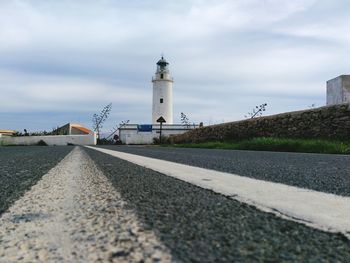 Surface level of lighthouse against cloudy sky