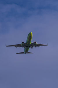 Low angle view of airplane flying against clear blue sky