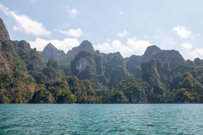 Scenic view of sea and mountains against sky