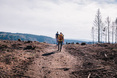 Full length of friends standing on mountain against sky