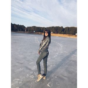 Full length portrait of young woman standing against sky