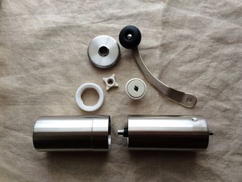 High angle view of coffee hand grinder parts on fabric