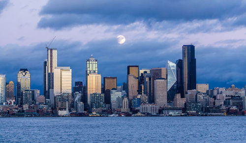 Full moon shines over the seattle skyline.