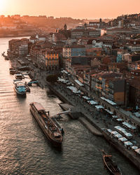 High angle view of buildings by sea against sky during sunset