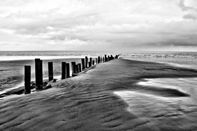 Scenic view of beach against cloudy sky