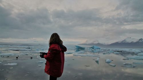 Rear view of woman looking at sea against sky