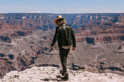 Rear view of man standing on rock