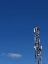 Low angle view of communications tower against blue sky