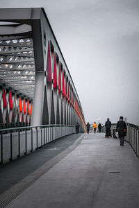 People on bridge against clear sky