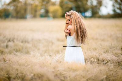 Portrait of young woman standing on field