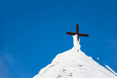 Low angle view of cross against blue sky