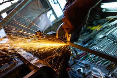 Cropped hand of person cutting metal