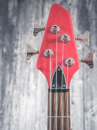 Close-up of red bell on wood against wall