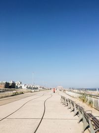 Street against clear blue sky