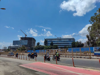 People on street against buildings in city