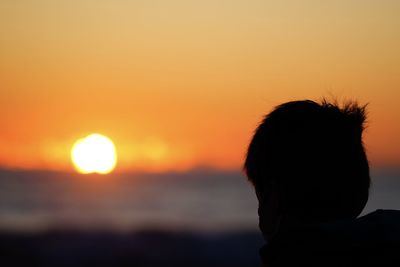 Silhouette of man looking at sunset