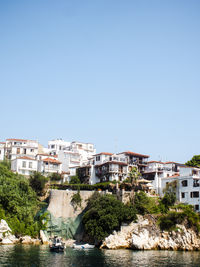 River amidst buildings against clear blue sky