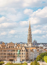 Buildings in city against cloudy sky