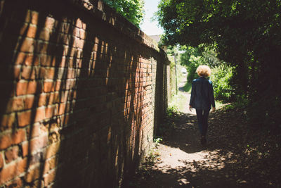 Rear view of woman walking on footpath