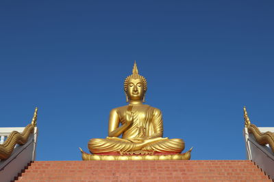 Low angle view of statue against building against sky