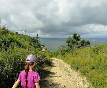 Rear view of woman looking at sea against sky