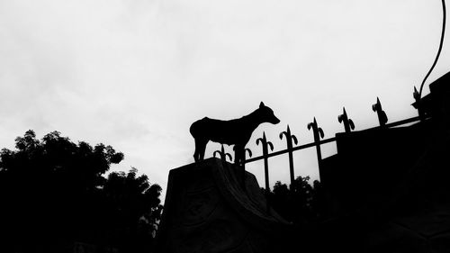 Low angle view of silhouette statue against sky