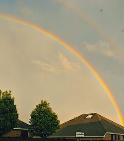 Rainbow over buildings against sky