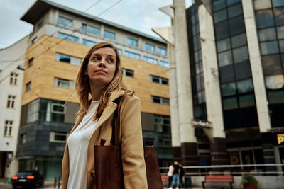 Woman standing against building in city