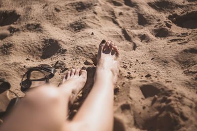 Low section of person on sand at beach