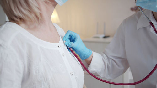 Midsection of doctor examining patient in clinic