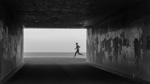 Running on the beach seen through a tunnel