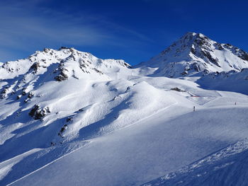 Scenic view of snowcapped mountains on sunny day