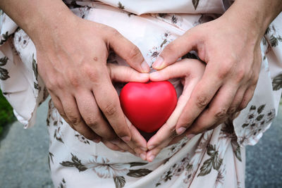 Midsection of couple holding heart shape