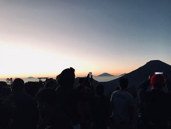 Silhouette people against sky during sunset