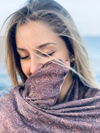 Close-up of smiling young woman wearing scarf