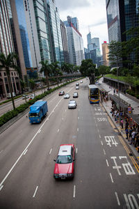 Cars on city street by modern buildings