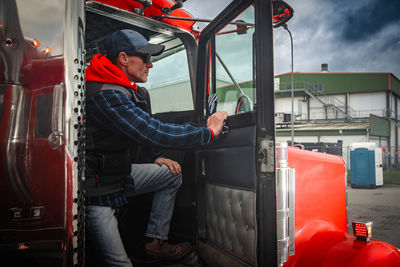 Rear view of man working in car